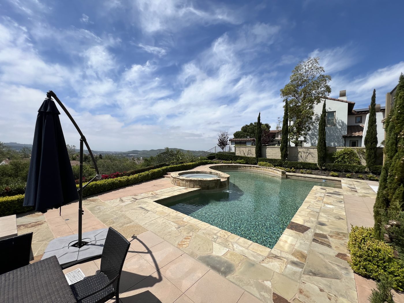 Backyard pool and spa with hillside view, ready for outdoor audio install