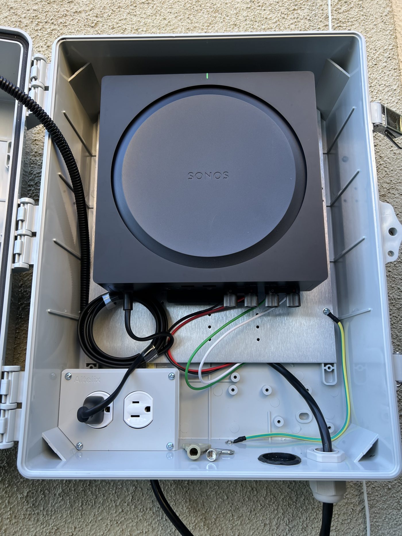 Weatherproof enclosure housing Sonos amplifier and power connections