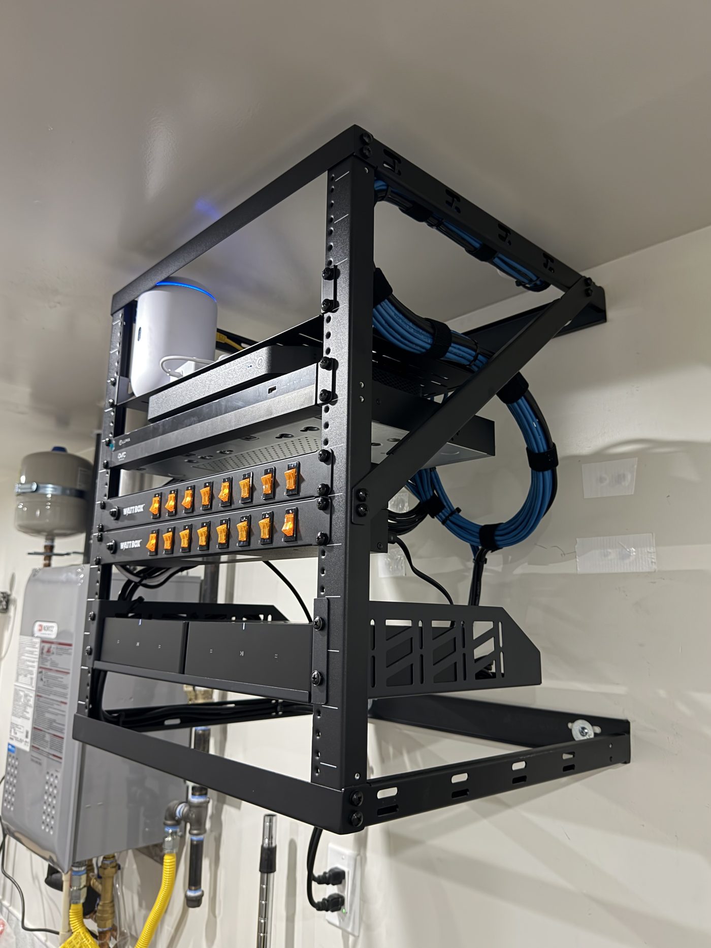 Wall-mounted equipment rack with WattBox power management and networking gear