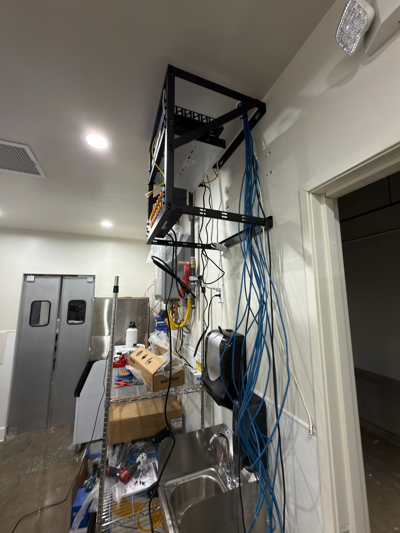 Equipment rack installed above kitchen prep area with structured cabling