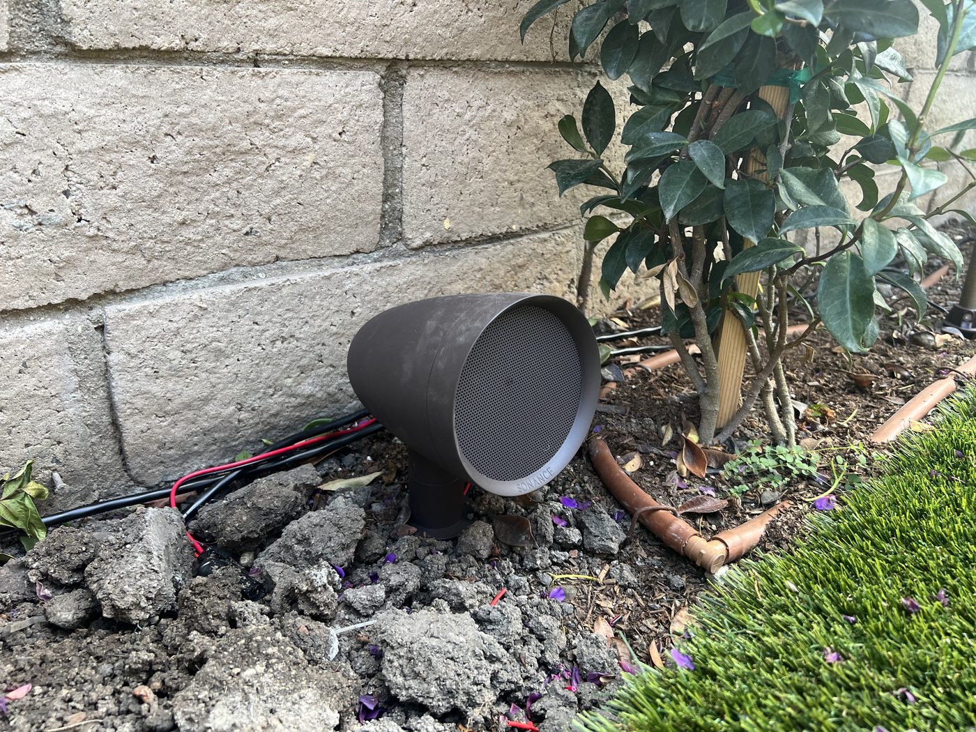 Outdoor landscape speaker installed in garden bed